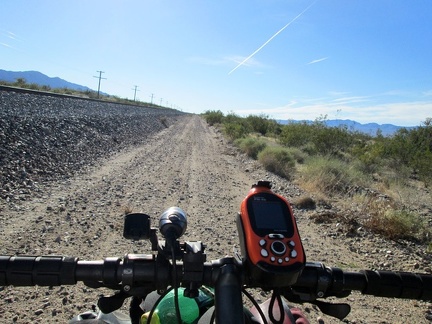 A jet-exhaust stream glides by effortlessly in the sky while I rattle along Nipton-Moore Road, hugging the train tracks