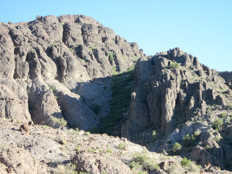 I zoom in closer and, yes, there is a slot in the cliffs that I might be able to hike