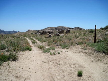 I pass through an old ranch fence and a sign marking the adjacent hiking trail