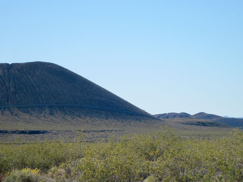 I zoom in across an expanse of yellow creosote-bush blooms to one of the nearby cinder cones